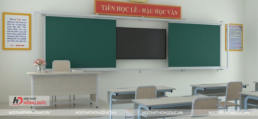 Bàn ghế giáo viên đặt cạnh hệ bảng trượt tích hợp màn hình trong phòng học