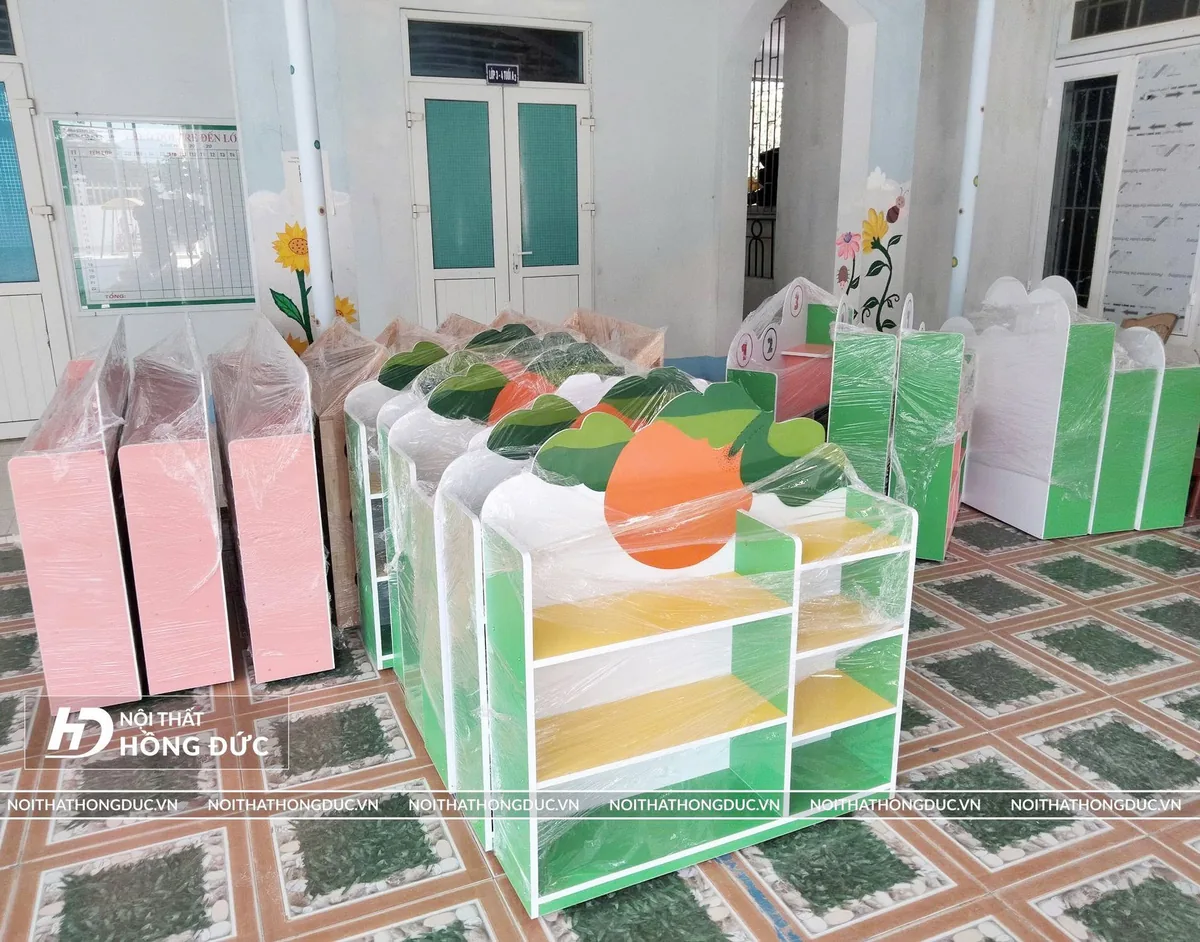 Dãy giá kệ mầm non nhiều màu xếp trong lớp, mỗi khoang một ngăn để đồ