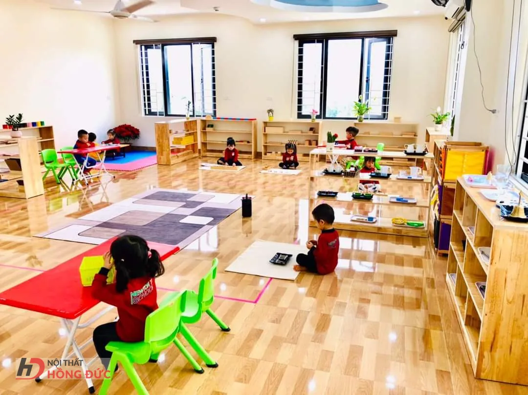 Lớp mầm non đã kê bàn ghế và giá để học cụ, trẻ đang hoạt động trong lớp