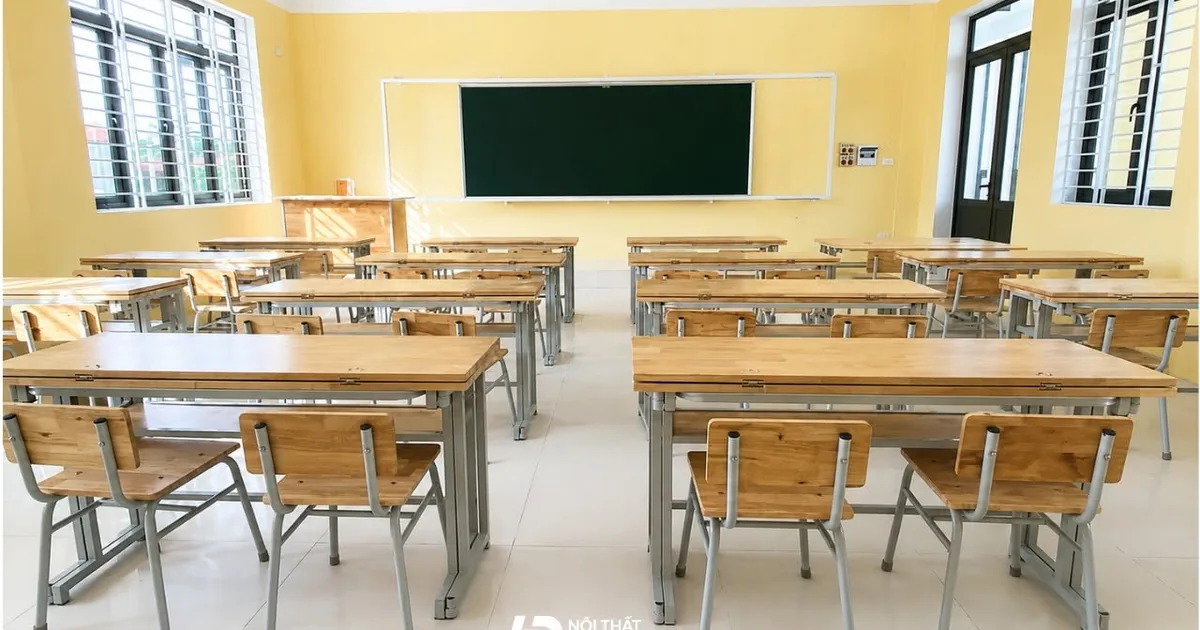 Phòng học đã lắp nhiều bộ bàn ghế gỗ khung sắt, phía trước lớp là bàn giáo viên