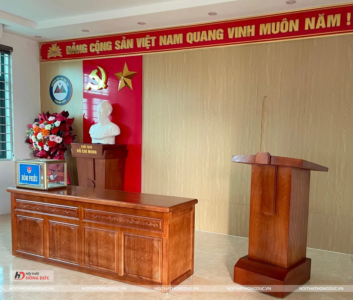 Sân khấu hội trường có bục phát biểu đặt bên phải, bục tượng Bác và bàn chủ tọa bên trái