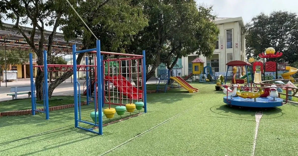 Sân trường mầm non nền cỏ nhân tạo đã bố trí đu quay và xích đu